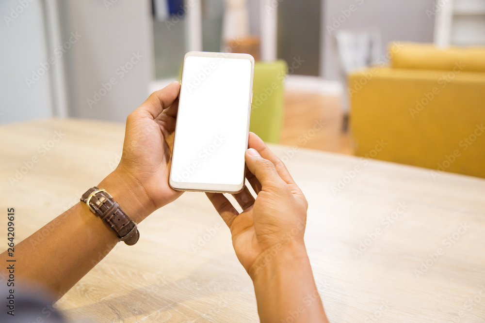 Wall mural mockup smartphone on businessman hands empty display on home table with blur background. - image - i