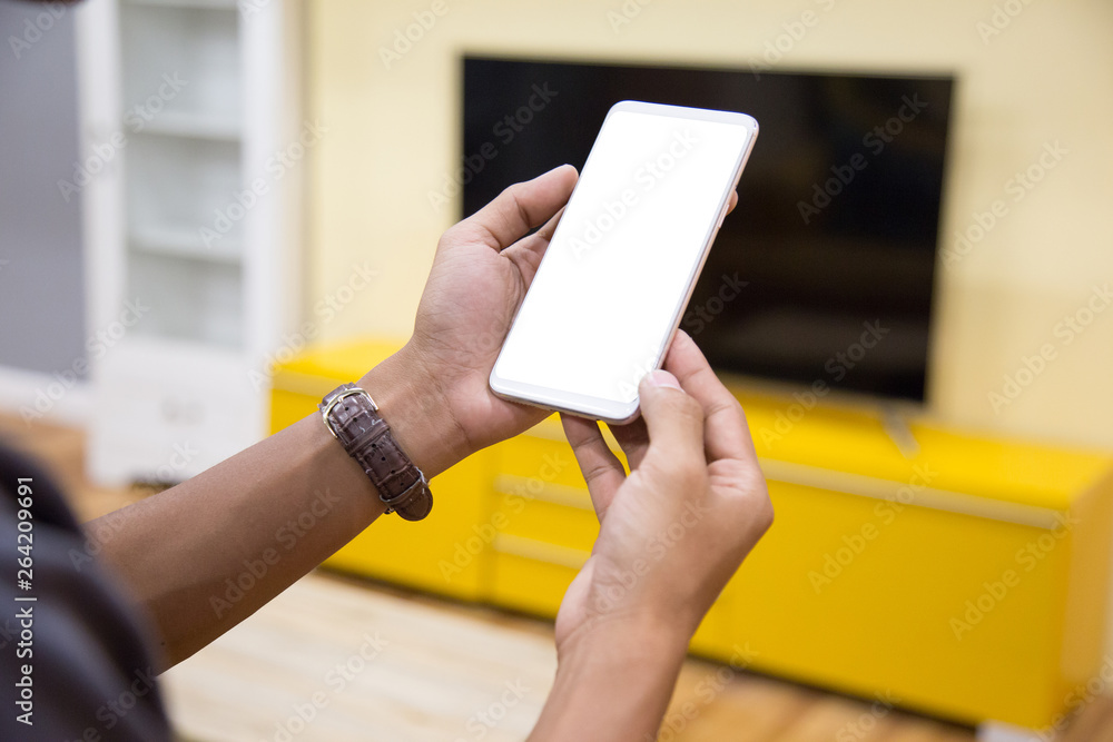 Wall mural mockup smartphone on businessman hands empty display on home table with blur background. - image - i