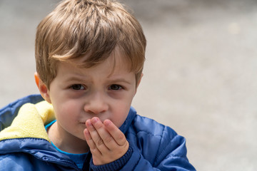 Small child eating popcorn in a park