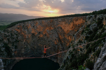 Mimi Guesdon walking in heels on a highline above the Red Lake, Split-Dalmatia, Imotski, Croatia