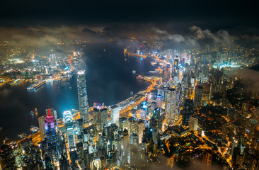 Aerial view of Hong Kong City skyline at night over the clouds