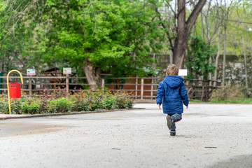 Fototapeta na wymiar Small child running in a park