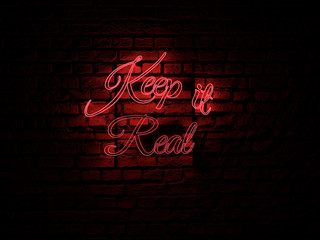 Red Neon Sign Text saying Keep it real over a red brick wall