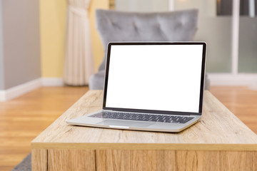 Fototapeta premium laptop showing blank screen on work table front view in home- Image