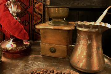 Copper coffee maker (turka), coffee grains and old coffee grinder on the table