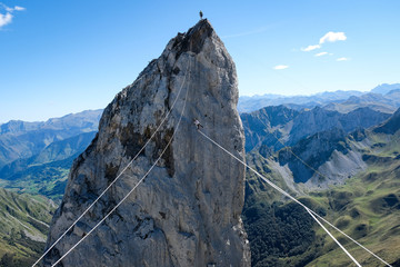 a man walking on a highline in the French Pyrenees with his friend on the top of a cliff,...