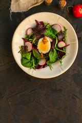 salad with radishes, egg and mix leaves lettuce, snack. food background. top view