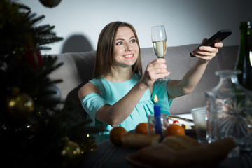 Woman  with wineglass watching TV