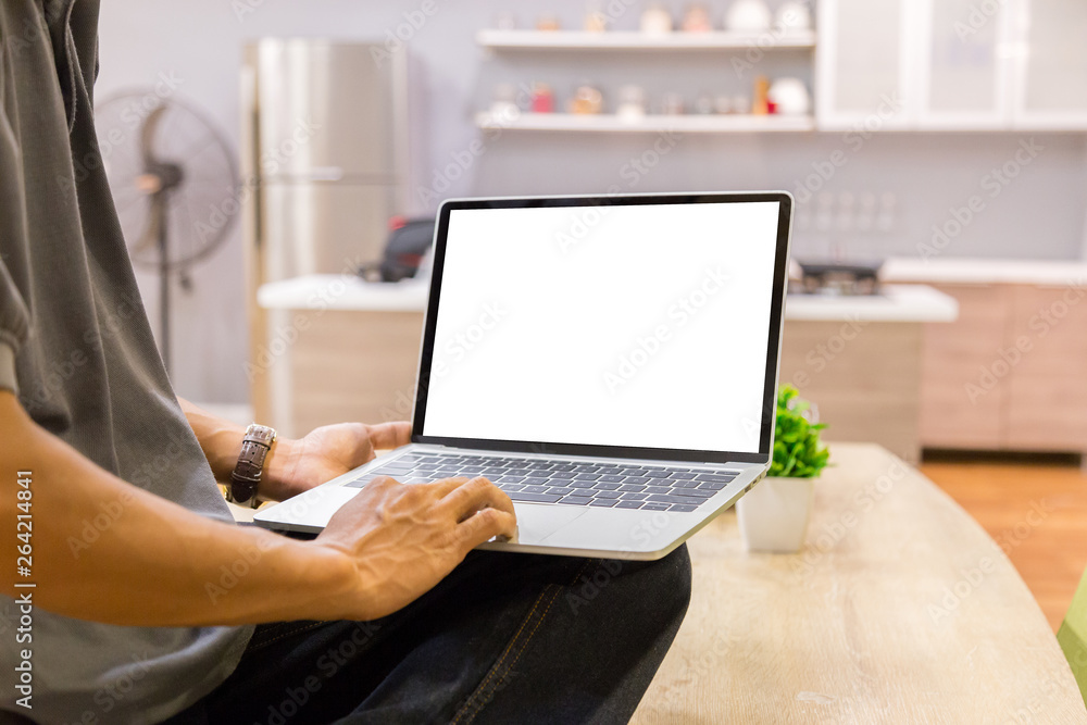 Poster mockup image of a businessman using laptop with blank white desktop screen working in home- image