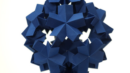 Sperical modular origami object. Close up blue origami ball isolated on white background. Japanese artwork and traditions.