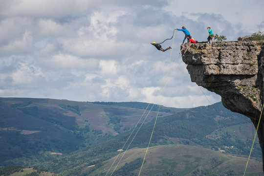 a man with his friends doing bungee jump from a peak, Occitanie, Florac, France