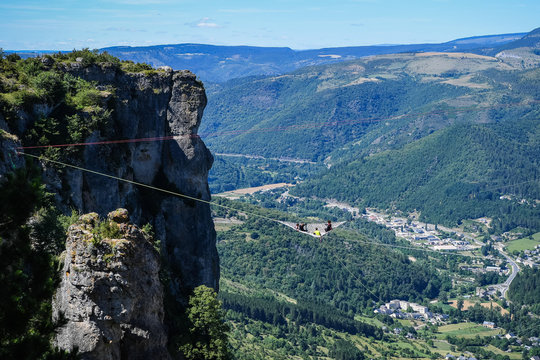 a group of people in a space net on the top of a cliff, Occitanie, Florac, France