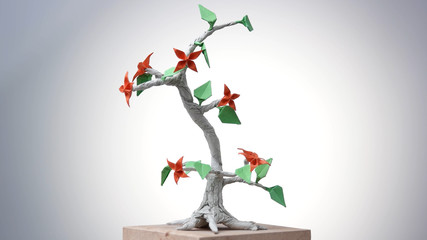 Beautiful origami bonsai. Decorative paper tree with leaves and flowers. Beauty of japanese art.