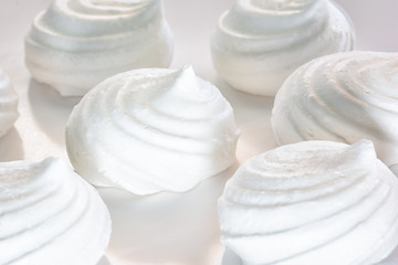 Fresh meringues close up. Delicious dessert. Background in blur.