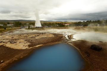 Icelandic landscape.Hot geyser spouting out of the ground and the endless Icelandic landscape.