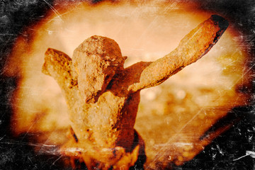 Retro styled destroyed ancient iron statue of the crucifixion of Jesus Christ