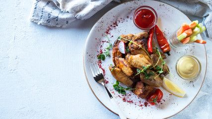 Tasty buffalo chicken wings  with  hot  red pepper, celery and carrot sticks. Top view. Space for text