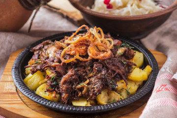 Beef tails with potato and onion on frying pan.