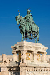 Fototapeta premium Hungary, Budapest, Castle Hill, Fischerbastei: Statue of St Stephen I at famous Fisherman's Bastion near Matthias Church above the city center of the Hungarian capital with blue sky - concept history.