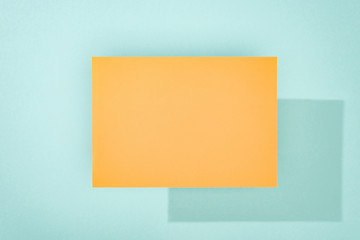 orange empty card with copy space and shadow on turquoise background