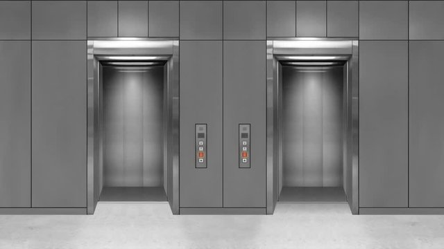 Sliding steel door elevator open showing lift interior. Office building with grey walls.