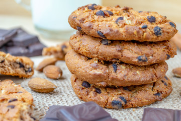 Oatmeal cookies with chocolates and nuts on a wooden table.