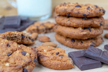 Oatmeal cookies with chocolates and nuts on a wooden table.