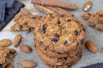 Oatmeal cookies with chocolates and nuts on a wooden table.