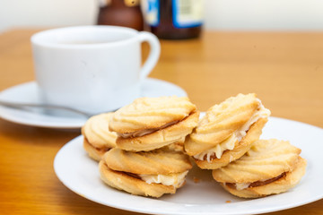 Fototapeta na wymiar Viennese whirls cakes on a white plate with a cup of coffee