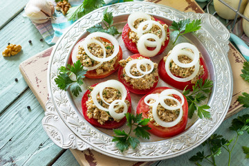 Georgian cuisine. Fresh homemade tomatoes and walnut coriander sauce on the kitchen wooden table. Copy space.