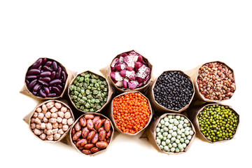 Various assortment set of indian legumes in paper sack bags isolated on white background.