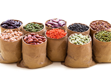Various assortment set of indian legumes in paper sack bags isolated on white background.