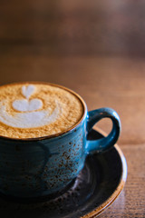 Half of the cappuccino cup on tabletop with copyspace