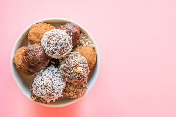 Homemade energy dates balls on pink background. Space for text.
