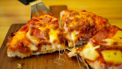 Pizza Three small pieces in a wooden tray on top  has delicious cheese.