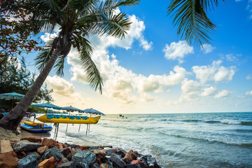 Beautiful early morning sunrise over Banana boat lays under Coconut tree with on the beach in the sea at Hat chao lao beach in Chanthaburi,Thailand.