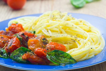 Pasta with tomatoes on blue plate