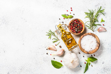 Spices, herbs and olive oil over white stone table.