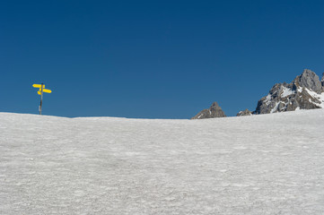 direction sign on a snow covered mountain top helping hikers to find their way