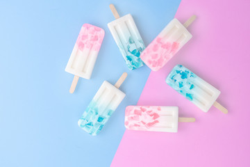 Homemade Ice cream sticks , popsicle , ice pop or freezer pop on blue and pink pastel colors background