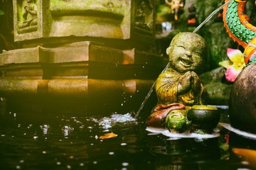 Old Cute Monk Statue be left in the Park with Light Leak Background.
