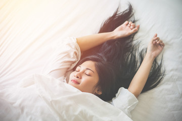 Beautiful young woman sleeping on bed at bedroom