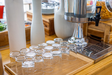 multiple rows of transparent empty glass bottles container for cool water at buffet self service at hotel.