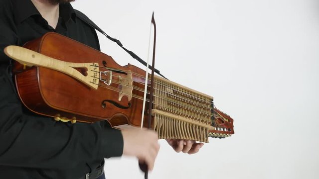 young musician plays nyckelharpa, medieval swedish Scandinavian authentic musical instrument, close-up