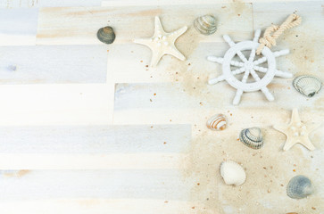 Maritime background with sand, shells and an old white wooden wheel