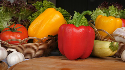 a background of many vegetables including pepper tomatoes garlic mushrooms vegetables on a wooden board