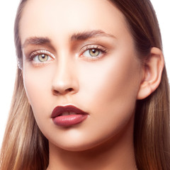 Close-up face of young fashion model woman with trendy red cherry marsala lipstick make-up, perfect skin, green eyes looking at camera