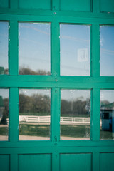 Green Door with Farm Reflected in Glass