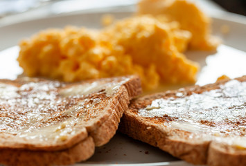 Scrambled eggs and toast. Focus is on toast