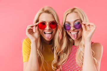 Funny blonde twins in sunglasses having fun - obrazy, fototapety, plakaty